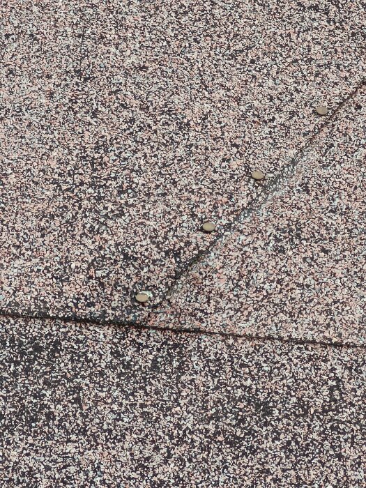 Papptak med synliga spikar längs en skarv, vilket tyder på felaktig takläggningsmetod.