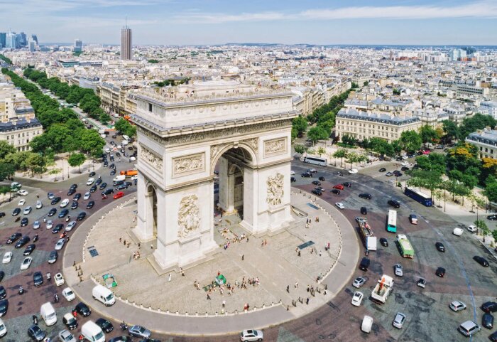 Luftfoto över Triumfbågen i Paris omgiven av trafik och omgivande stadslandskap.