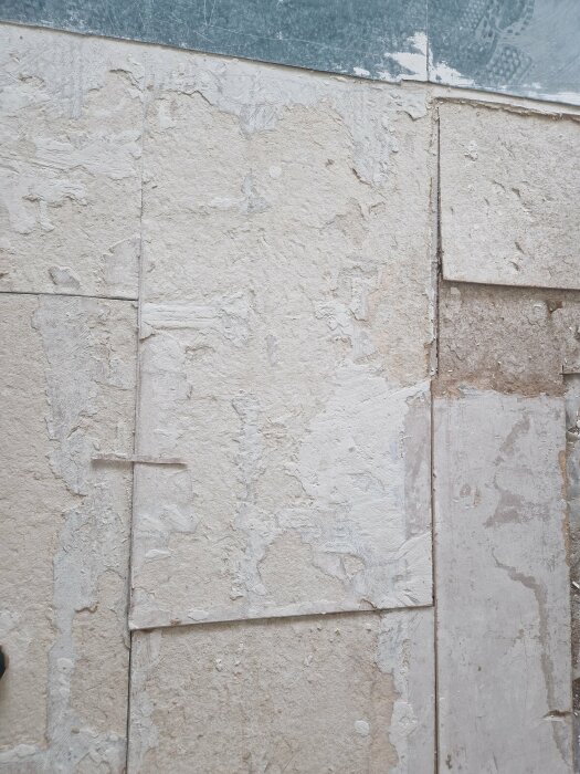 Förstörda golvspånskivor i en lägenhet som ska bytas, med synliga skador och slitage på ytan.