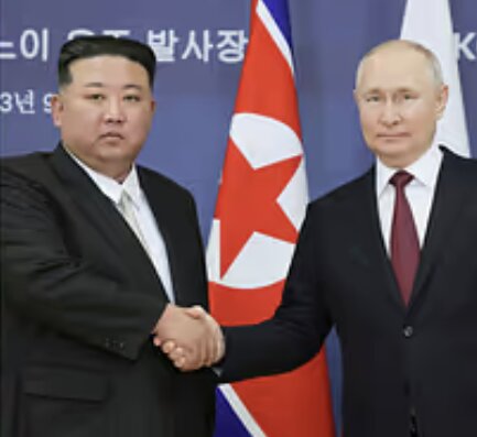 Två män klädda i kostym skakar hand framför nordkoreanska och ryska flaggor.