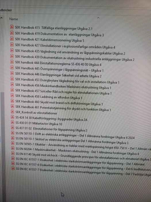 Bild på en datorskärm som visar en lista med elhandböcker med titlar som "SEK Handbok 415 Tillfälliga elanläggningar Utgåva 2.1" och "SS EN 50110-1 Drift av elektriska anläggningar".