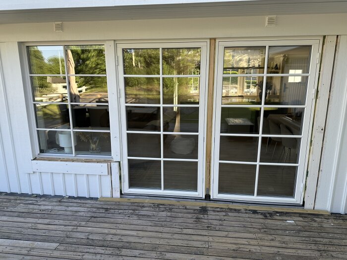 Två 120 cm breda dörrar med glaspartier installerade bredvid varandra, set från altanen mot vardagsrummet.
