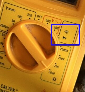 Närbild av instrumentpanel på en maskin med säkerhetsbrytare och diagnosticeringsklistermärken, markeringen visar säkringspositioner.
