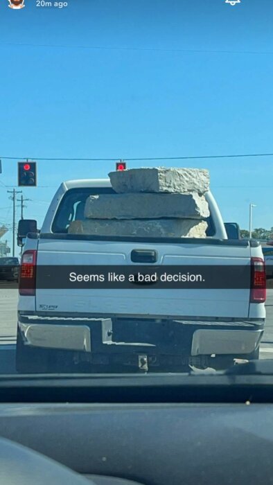 En pickuptransportbil som fraktar stora stenblock på flaket, med övertexten "Seems like a bad decision" och röd trafiksignal i bakgrunden.