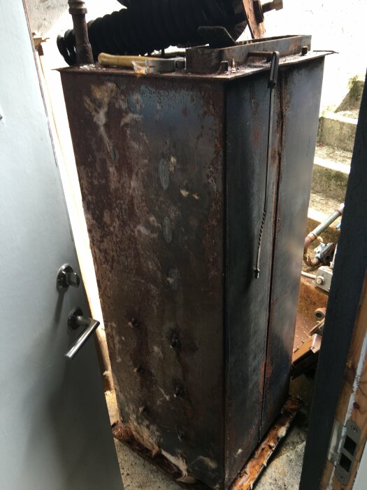 Rostig metallpåse vid dörröppning, redo att kapas i mindre bitar.