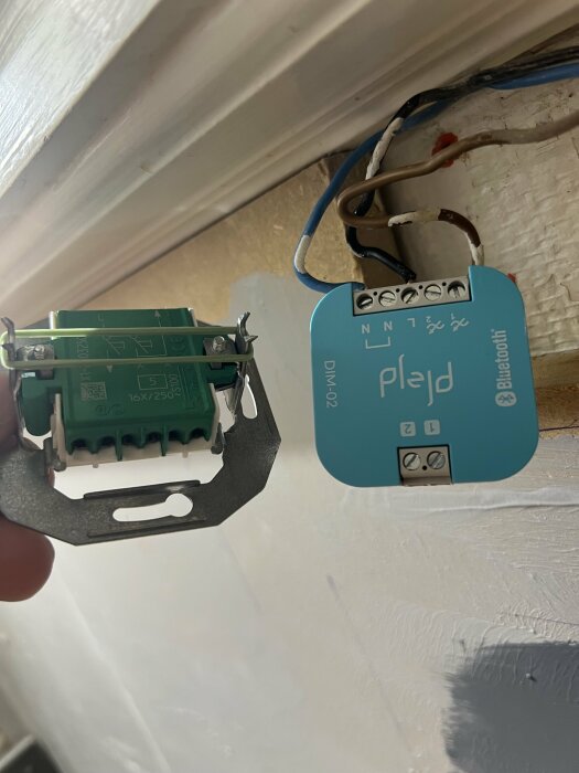 Två elektriska komponenter, en RENOVA och en Plejd dimmer, visas med frågan om var man ska koppla kablarna från Plejd till RENOVA.