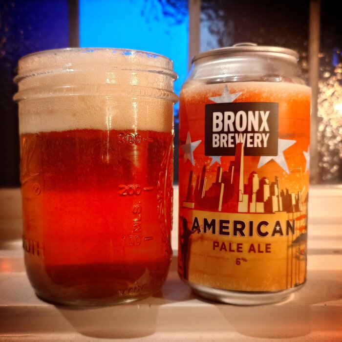 En burk Bronx Brewery American Pale Ale på 6% samt ett glas fyllt med samma öl, på ett fönsterbräde.