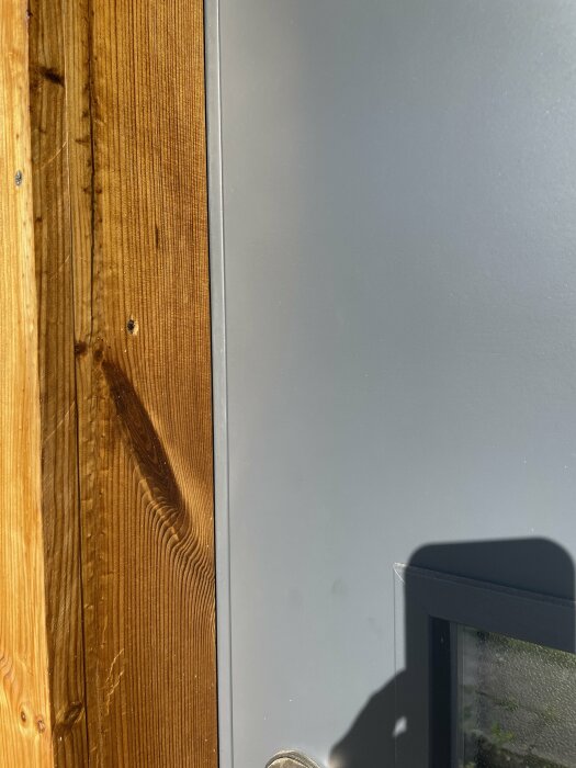 Bild på ytterdörr med dagsljus som tränger igenom springan mellan dörr och karm på handtagssidan, vilket visar en dålig tätning.
