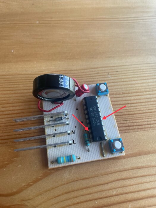 Kretskort med komponenter för styrning av element, inklusive en stor kondensator (1F, 5,5V) och markerade IC-stift, på ett trägolv.