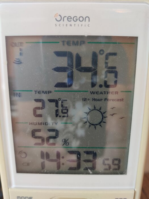 Visar en digital termometer med temperaturerna 34,6°C ute och 27,6°C inne, samt luftfuktighet 52% och klockan 14:33.