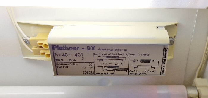 Närbild av en äldre Platinor DX lysrörsarmatur med specifikationer på en etikett för lampor typ 40-431, inklusive eldiagram och kapacitet: 1x40W eller 2x20W.