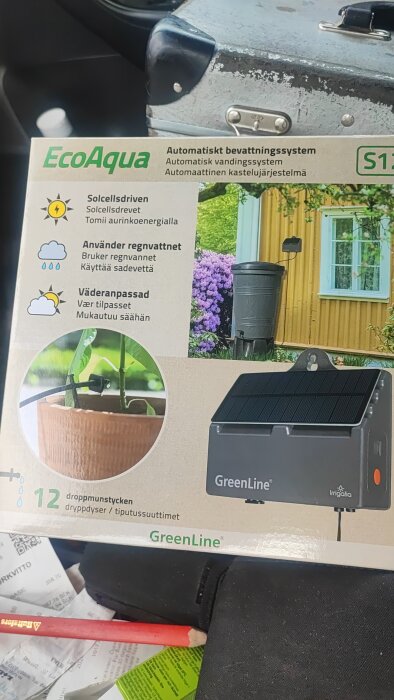 Förpackning av EcoAqua automatiskt bevattningssystem som är solcellsdrivet, använder regnvatten och är väderanpassat.