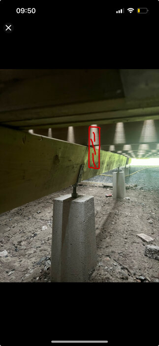 Träregel under ett trädäck stödd av betongpelare, med en röd markering som föreslår placering av en 45x95 mm förstärkning för att förhindra att regeln böjer sig.
