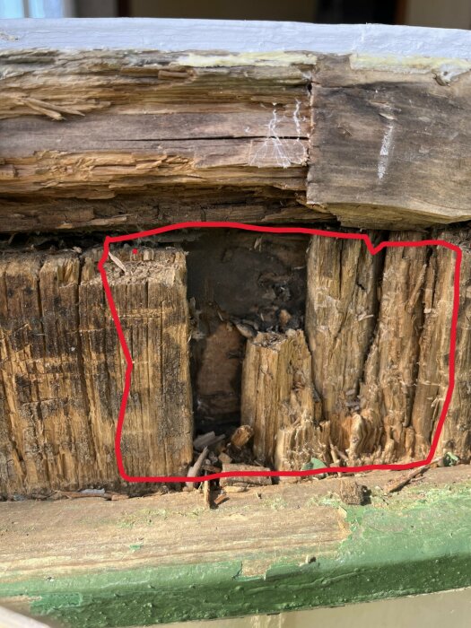 Rötskadat trä med en del omgjord markering. Den röda markeringen visar det område som behöver bytas ut som en tillfällig åtgärd.
