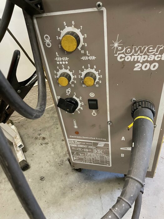 Svetsmaskin ESAB Power Compact 200 med reglage och sladdar, fotograferad på ett garagegolv i Gnesta.
