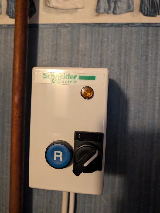 Motorskydd från Schneider Electric med en blå knapp märkt "R" och en omkopplare med lägena "0" och "1".