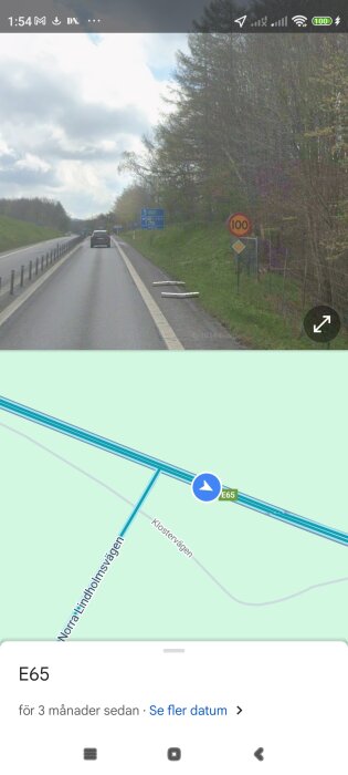 En landsväg med en hastighetsskylt som visar 100 km/h och en vägskyl med riktning mot E65 samt en karta som visar korsningen mellan E65 och Klostervägen.