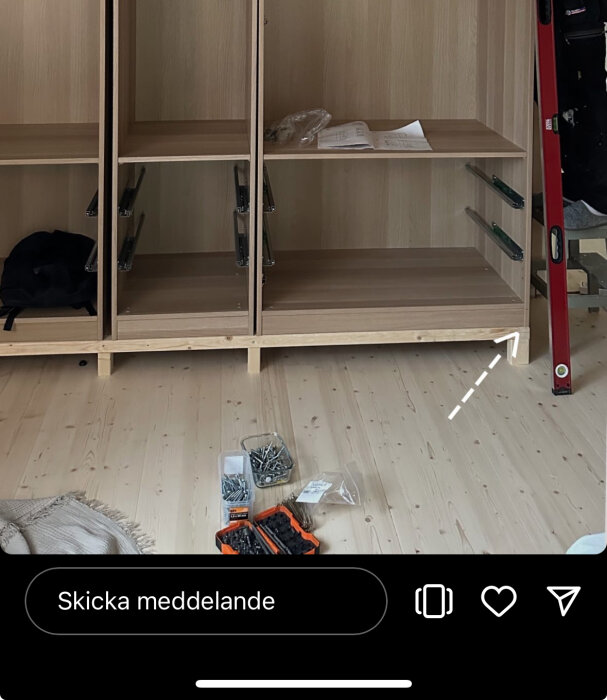 Pax garderobsstommar från Ikea monterade, med skruvar och redskap på golvet, samt en stegstege till höger.
