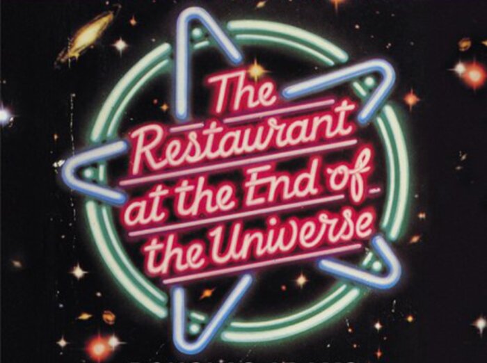 Neonskylt med texten "The Restaurant at the End of the Universe" på en svart bakgrund med stjärnor och galaxer.