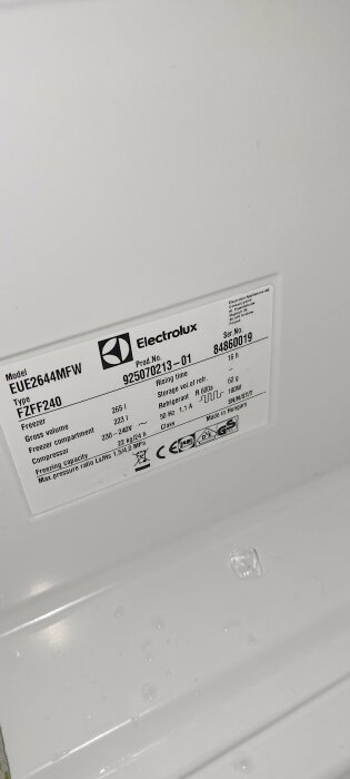 Informationsetikett på insidan av en Electrolux-frys med modellnummer EUE2644MFW och serienummer 84860019.