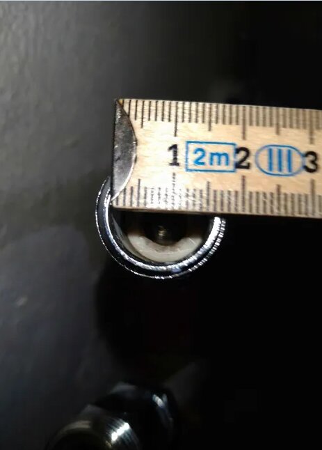 Måttband mäter en R15 till R12 förminskning på en metallkomponent.