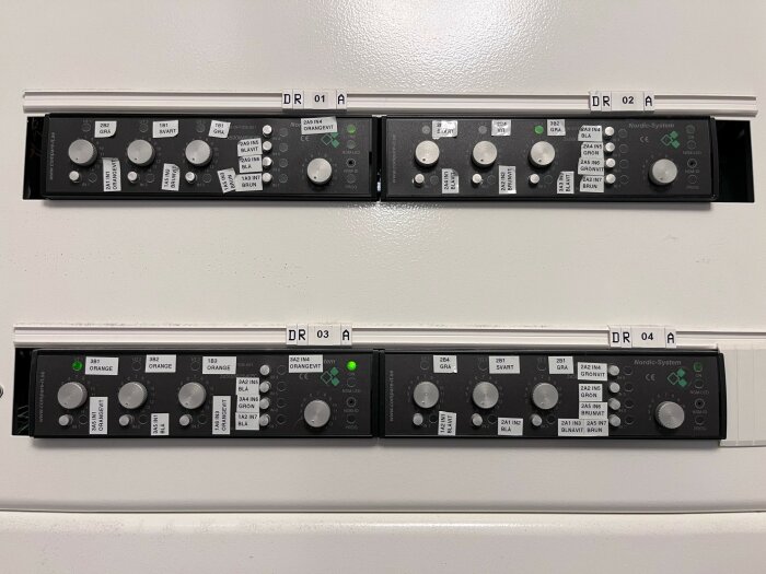 Fyra modulära lampställen med styrreglage och etiketter, märkta "Nordic-System". Varje modul har flera knappar och spakar för justering av belysning.