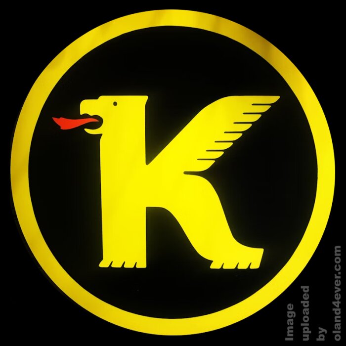 Gul logotyp för KOPPARTRANS med en bevingad häst i form av bokstaven "K" på en svart bakgrund inom en gul cirkel.