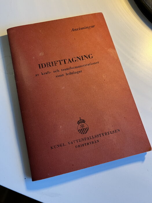 Boken "Anvisningar för idrifttagning av kraft- och transformatorstationer samt ledningar" från Kungl. Vattenfallsstyrelsen ligger på ett bord.