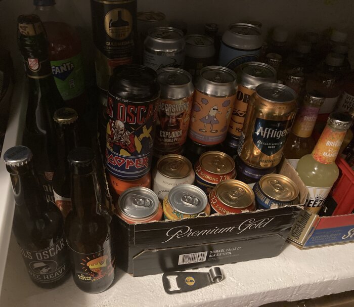 En matkällare fylld med olika ölflaskor och burkar, inklusive märken som S:t Eriks, Brewski och Affligem, samt andra drycker som Breezer och Fanta.