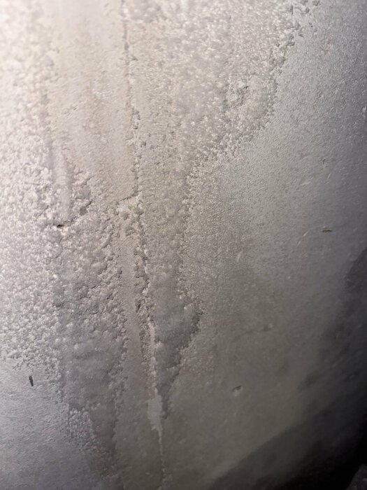 Närbild av en vägg i lättbetong med vita, frostlika fläckar och ojämn textur, eventuellt indikerande på fukt eller mögel efter applicering av mögelfri behandling.