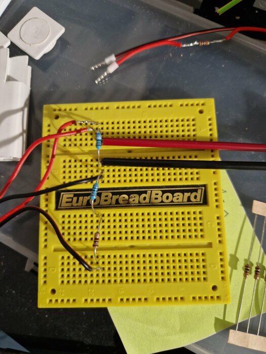 Gul kopplingsdäck med två motstånd, ett blått på 1.1K ohm och ett brunt på 3.9K ohm, samt röd/svart kablage ansluten med hjälp av wago-kopplingar.