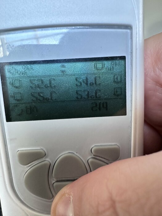 Närbild på en termostat där man kan läsa av temperaturerna 52.6°C, 54.0°C, och 53.6°C på en digital display. En persons tumme syns trycka på en knapp.