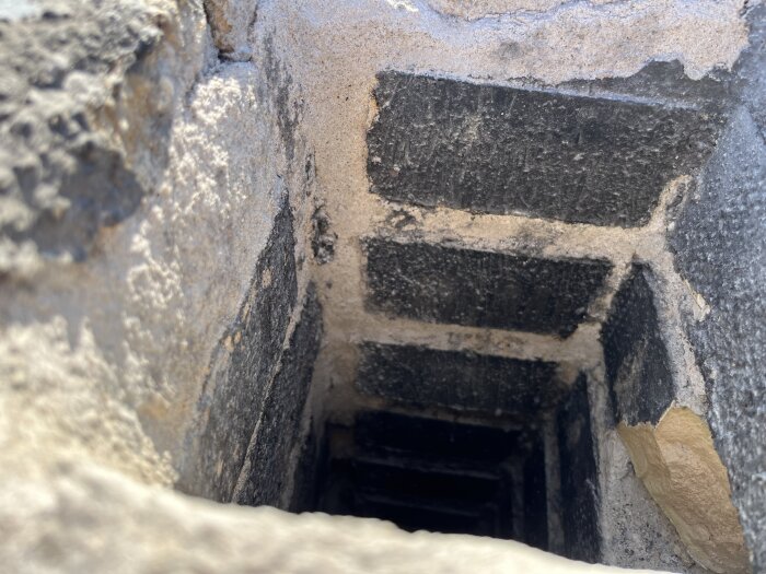 Insida av en skorsten med svart beläggning på tegelstenarna, upptäckt under en rivning.