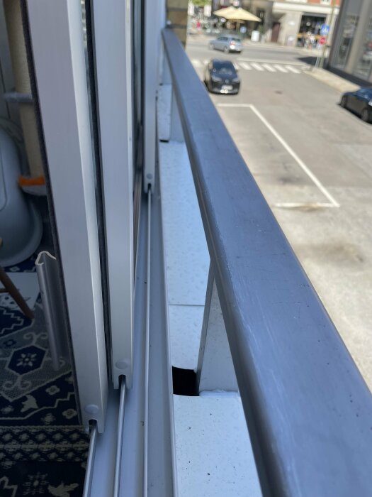 Inglasad balkong med glipor mellan fönsterkarm och räcke.