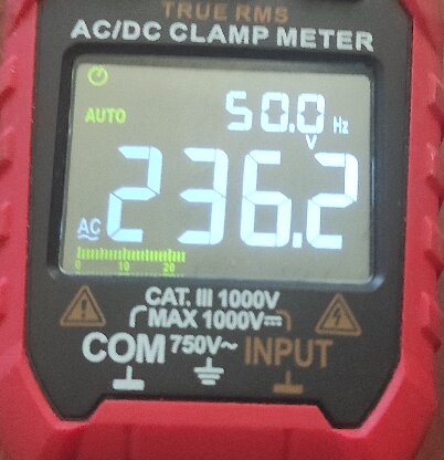 Närbild på en AC/DC klämma amperemeter som visar en mätning på 236,2 volt och 50,0 Hertz.