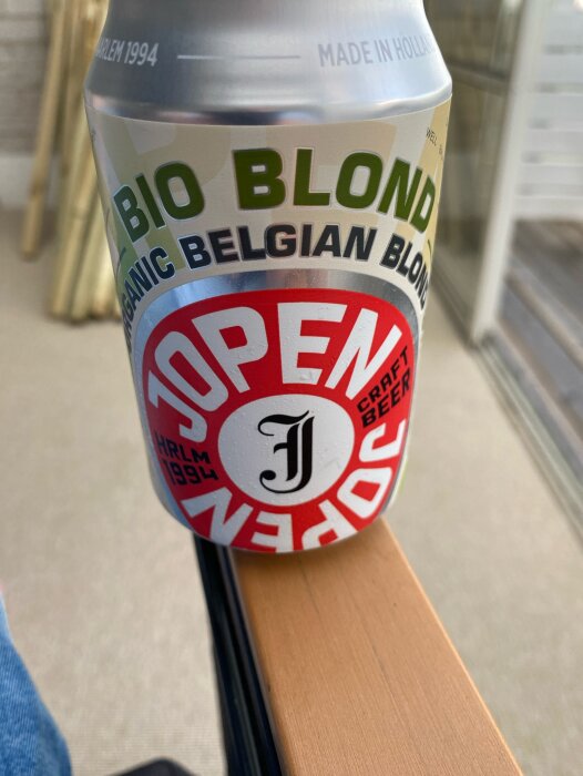 En burk Jopen Organic Belgian Blonde Ale på ett armstöd, etiketten visar texten "Bio Blond" och "Craft Beer.