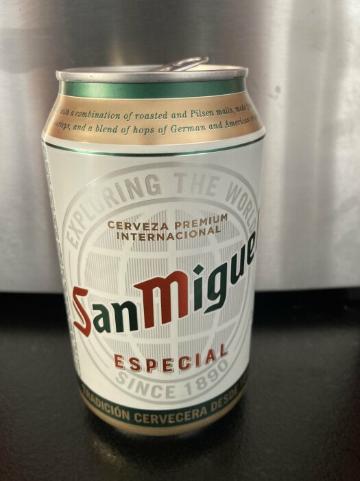 En burk San Miguel Especial öl med texten "Cerveza Premium Internacional" och "Exploring the World" synlig på etiketten.