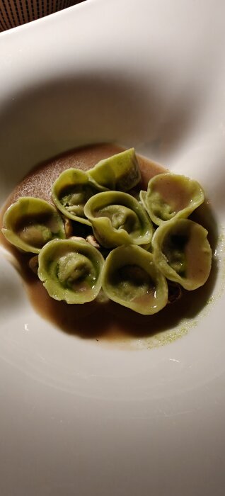 Gröna pastaknyten i vit skål, troligen en siciliansk maträtt.