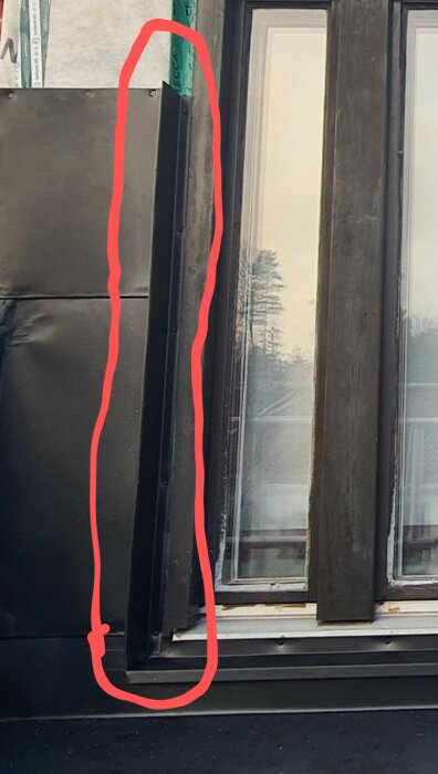 Fönster med plåtning kring fönsterbrädan, markerad med en röd linje, som ska sammanfogas korrekt under ett nyligen genomfört takbyte.
