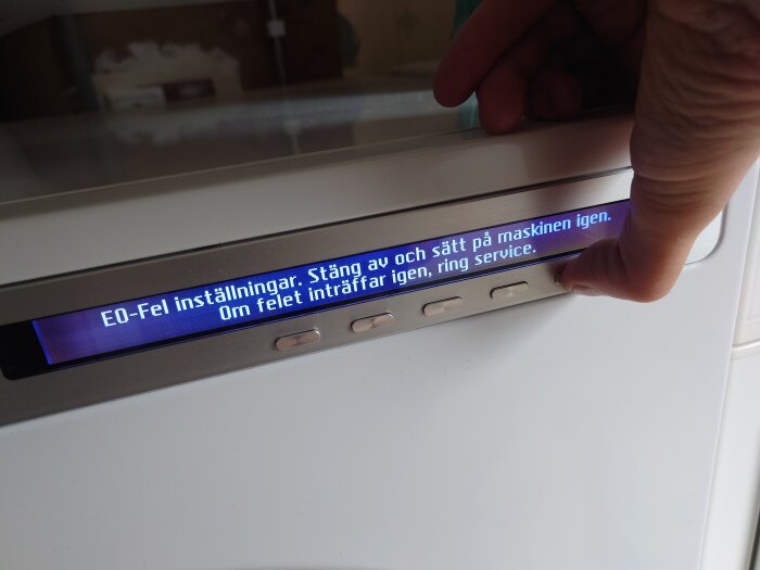 En diskmaskinsdisplay visar ett felmeddelande "E0-Fel inställningar. Stäng av och sätt på maskinen igen. Om felet inträffar igen, ring service.