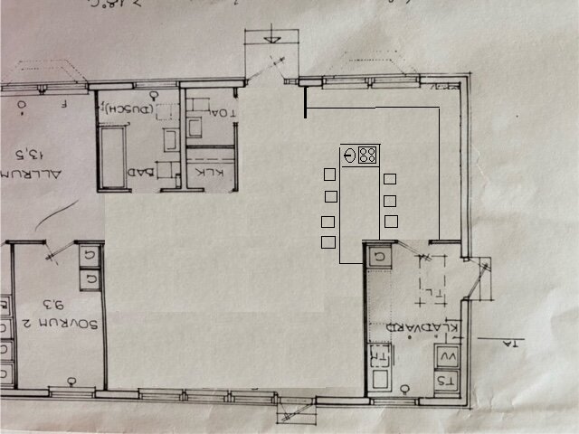 Ritning av en våningsplan som visar olika rum inklusive kök med matplats, badrum och sovrum. Kökets placering och layout är markerade i mitten.