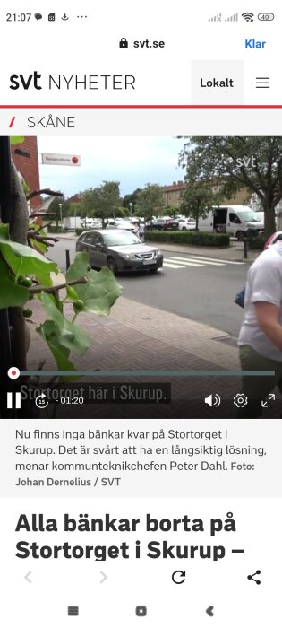 Reportagevideo från SVT Nyheter om att bänkar tagits bort från Stortorget i Skurup. Bilden visar en gata med bilar och gående vid en korsning nära Systembolaget.