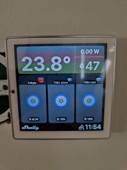 Shelly Wall Display som visar temperaturen 23,8 grader, luftfuktighet 47%, och kontroller för Frikyla, Fläkt söder, och Fläkt norr. Tid 11:54.