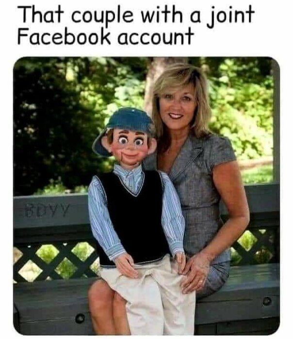 Kvinna med blondt hår som sitter på en bänk och håller en ventriloquistsdocka med keps och väst. Text ovanför: "That couple with a joint Facebook account".