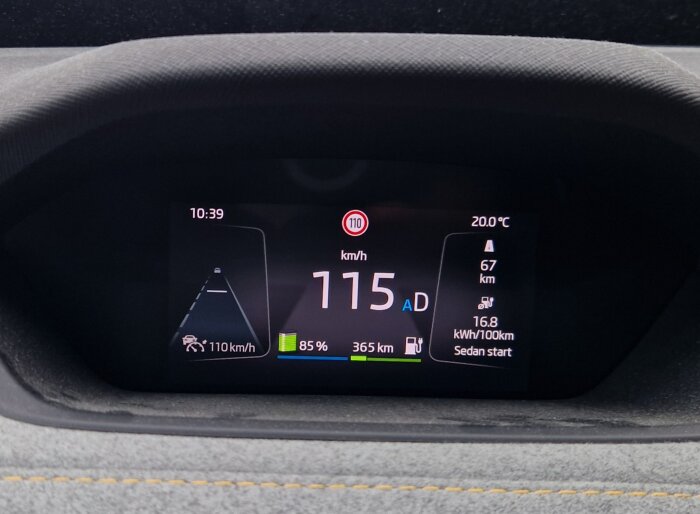 Digital instrumentpanel i Skoda Enyaq som visar hastigheten 115 km/h, batterinivå på 85 %, återstående räckvidd på 365 km och en genomsnittlig förbrukning på 16,8 kWh/100 km.