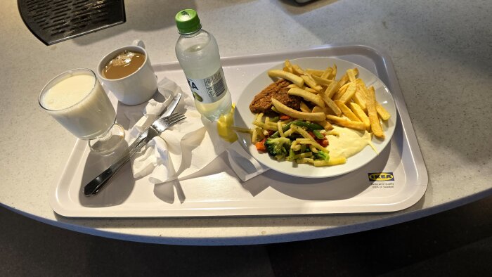 Matbricka på IKEA med en kaffe, ett glas dricka, en flaska vatten, och tallrik med pommes, kycklingbit, sallad och sås.