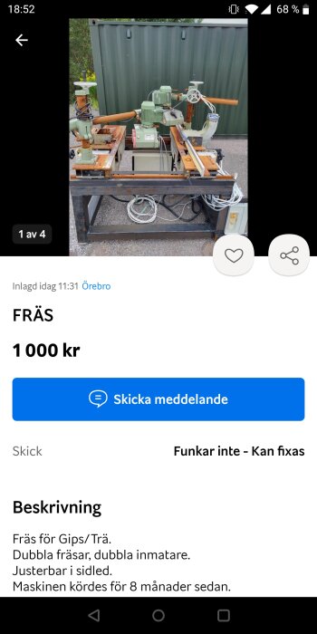 Industrifräsmaskin med dubbla fräsar och dubbla inmatningsanordningar, stående utomhus framför en grön container. Maskinen är rostig och avstängd.