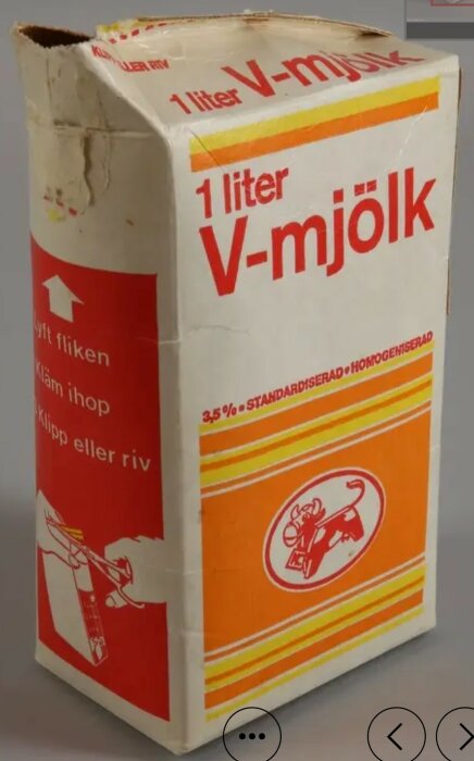 En kartong av 1 liter V-mjölk från Arla, märk 3,5% standardiserad och homogeniserad. Kartongen visar teckningar för hur den öppnas.