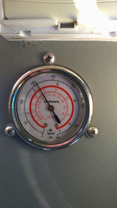 Manometer visar trycket på 310 psi för en värmepump, med markeringar för olika trycken i psi och kg/cm² samt temperatur i °C och °F.