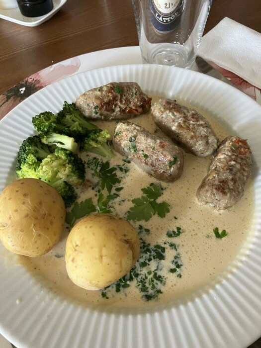 Tallrik med järpar, kokt potatis, broccoli och sås.